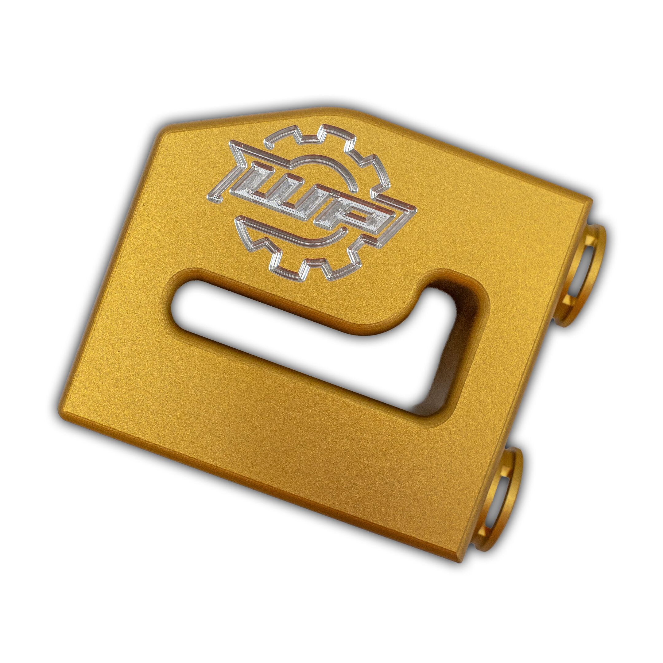 thermalbypass_13-19_3 - WP Developments close-up of a gold plastic handheld device with a silver embossed gear-like logo on its surface and a finger hole at the bottom corner.